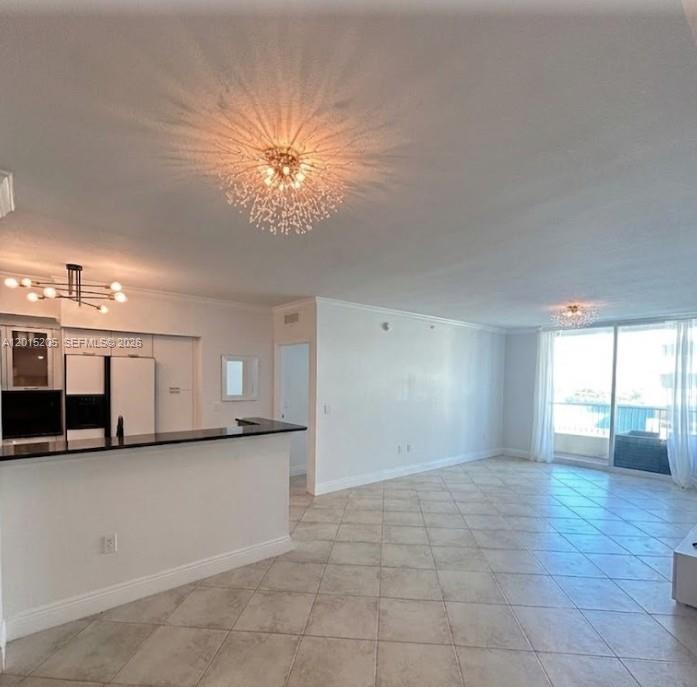An open-concept living area features a kitchen with a breakfast bar and tiled floors — 625 Casa Loma Blvd # 1009, Boynton Beach FL 33435, BOYNTON BEACH, FL