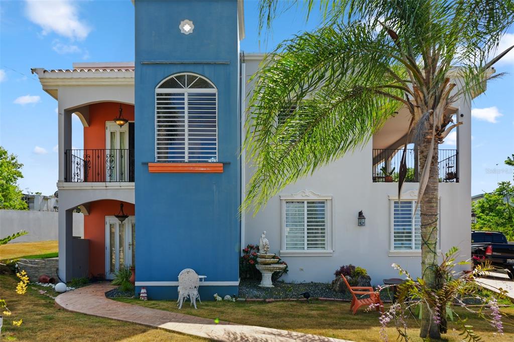 A two-story house with a blue tower, arched windows, and a palm tree in front — 8466 CALLE LOS LUGO, QUEBRADILLAS, PR