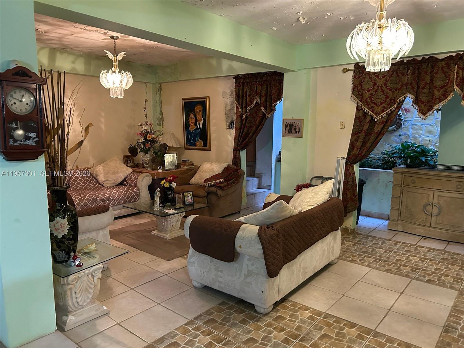 A living room features light green walls, tiled floors, two chandeliers, and traditional furniture — 262 W Cruz de Malta, PR 00685, PR