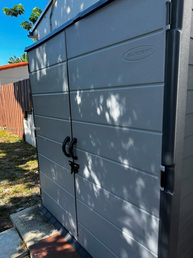 A gray Suncast storage shed stands outdoors on a concrete pad next to a fence — 1201 NE 148th St # B, Miami FL 33161, MIAMI, FL