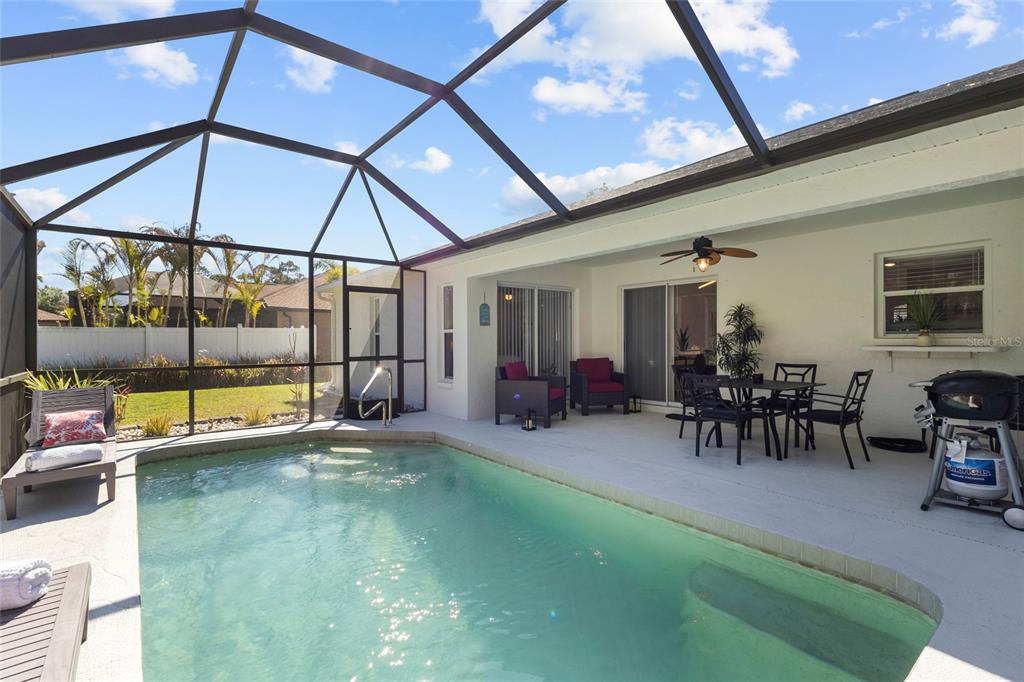 A screened-in patio features a swimming pool, outdoor dining set, and lounge chairs — 3620 CANDIA AVENUE, NORTH PORT, FL