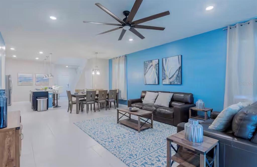 A living room and dining area with a blue accent wall and tile flooring — 2226 LELANI CIRCLE, DAVENPORT, FL