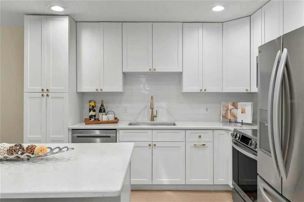A modern kitchen features white shaker cabinets, a marble island, and stainless steel appliances — 894 JONATHAN WAY UNIT 3B, ALTAMONTE SPRINGS, FL
