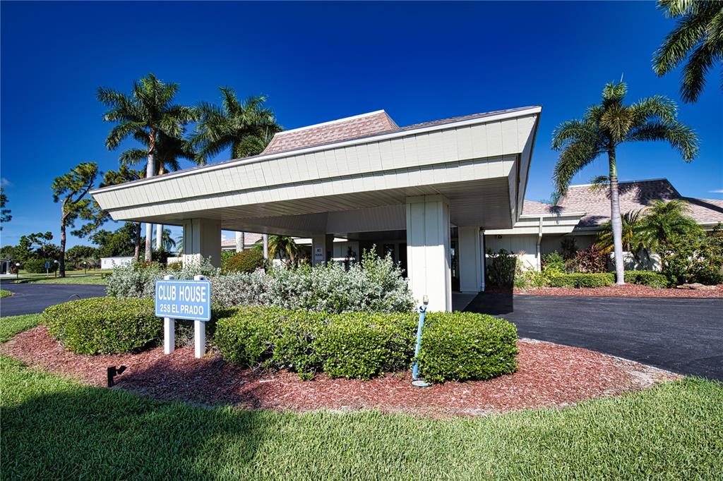 A covered entrance leads to a clubhouse building surrounded by palm trees and landscaping — 412 MADONNA, NORTH PORT, FL