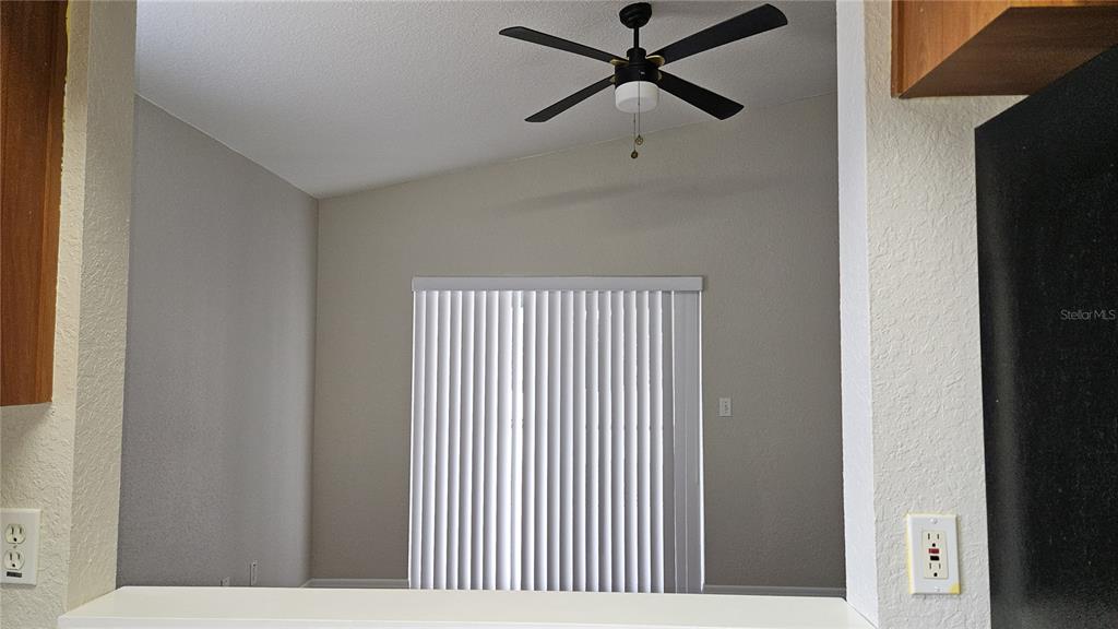 A view from a kitchen counter looking into a living area with a ceiling fan — 108 BRITTANY AVENUE, MASCOTTE, FL