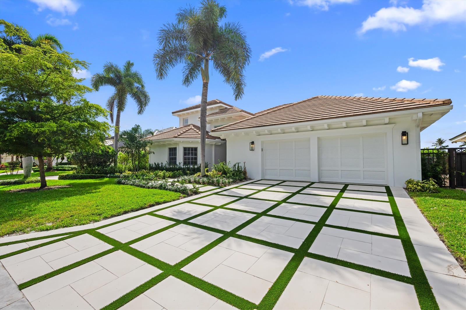 A white house with a two-car garage and a grid-patterned paver driveway with grass — 204 Birkdale Lane, Jupiter FL 33458, JUPITER, FL