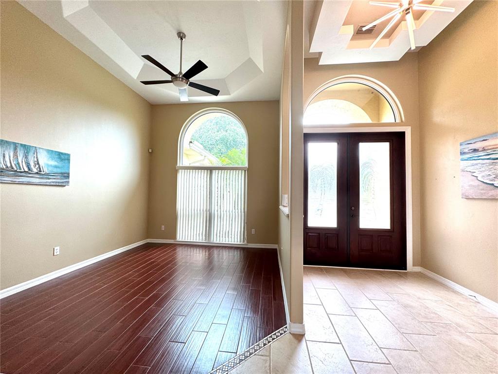 An entryway with tile flooring leads to a living area featuring dark wood floors — 17 PROMENADE AT LIONSPAW, DAYTONA BEACH, FL