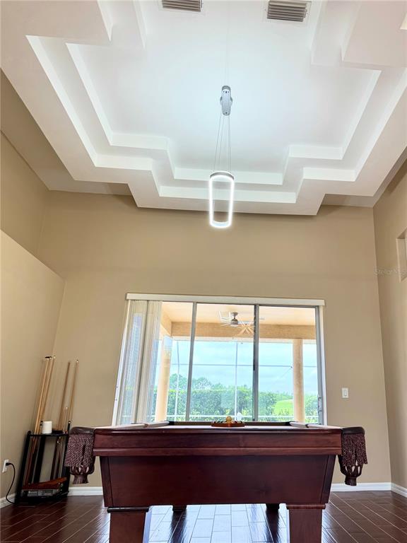 A room with a pool table, high tray ceiling, and sliding glass doors to a lanai — 17 PROMENADE AT LIONSPAW, DAYTONA BEACH, FL