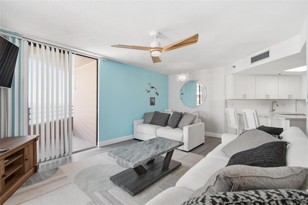 A living room features a blue accent wall, a marble coffee table, and a ceiling fan — 3023 S ATLANTIC AVENUE UNIT 903, DAYTONA BEACH, FL