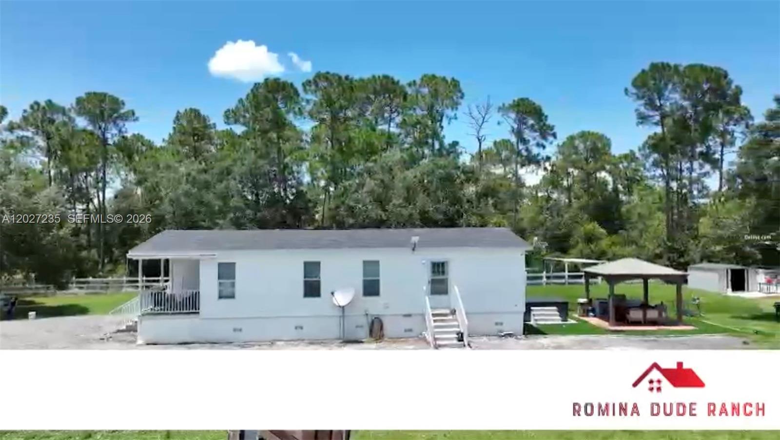 An exterior view of a white mobile home with a porch and a wooden gazebo — 725 N Willows St # 0, Clewiston FL 33440, CLEWISTON, FL