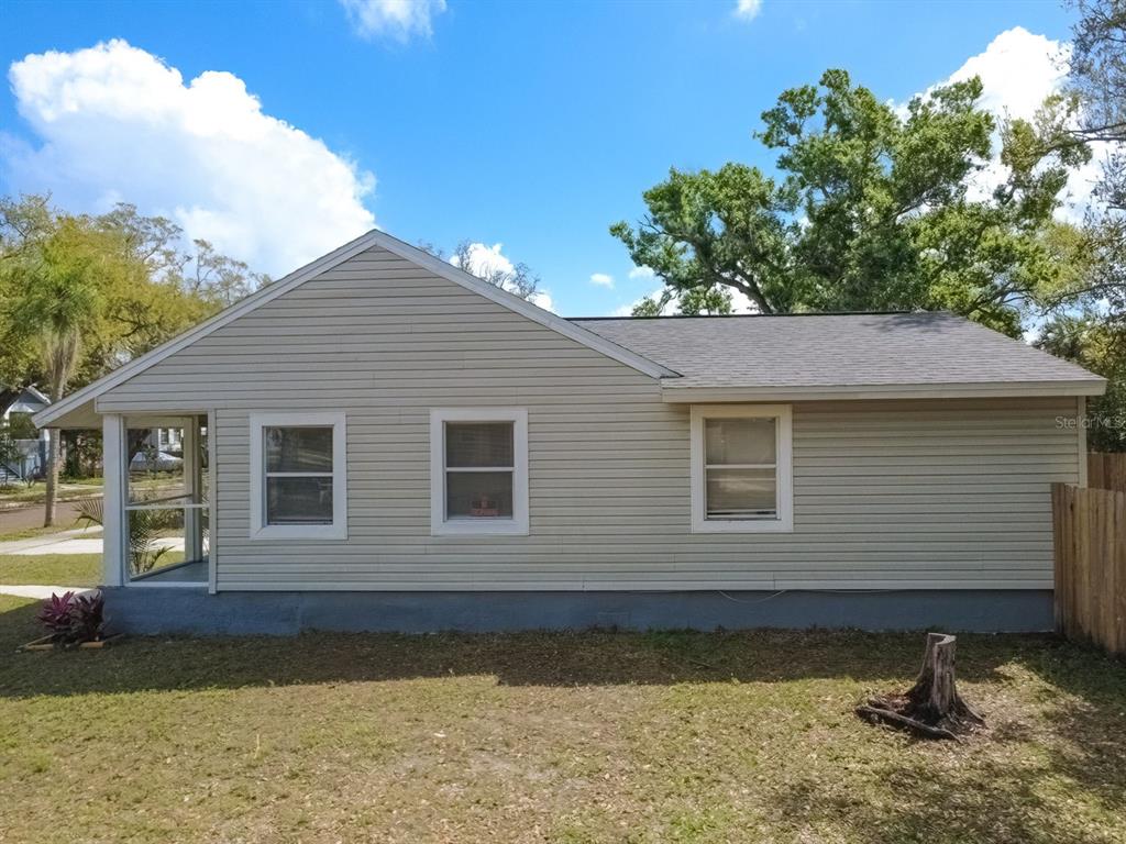 The exterior side view of a light-colored, single-story house with a screened-in porch — 546 16TH AVENUE S, ST PETERSBURG, FL
