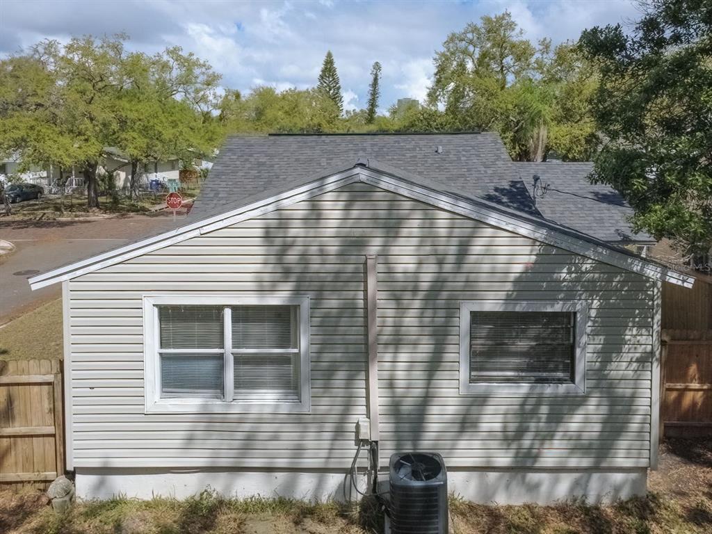 The exterior of a house features light-colored vinyl siding, two windows, and an air conditioning unit — 546 16TH AVENUE S, ST PETERSBURG, FL