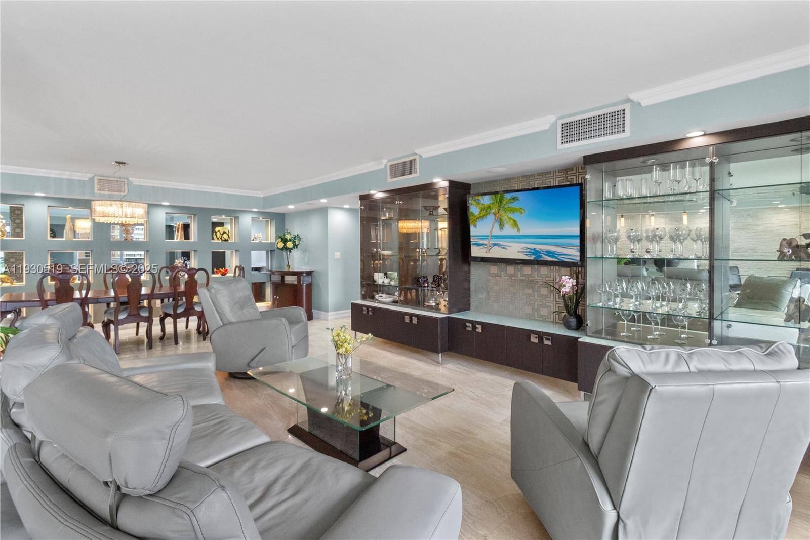 A living room features gray leather furniture, a glass coffee table, and a built-in entertainment center — 1880 S Ocean Dr, Hallandale Beach FL 33009, HALLANDALE BEACH, FL