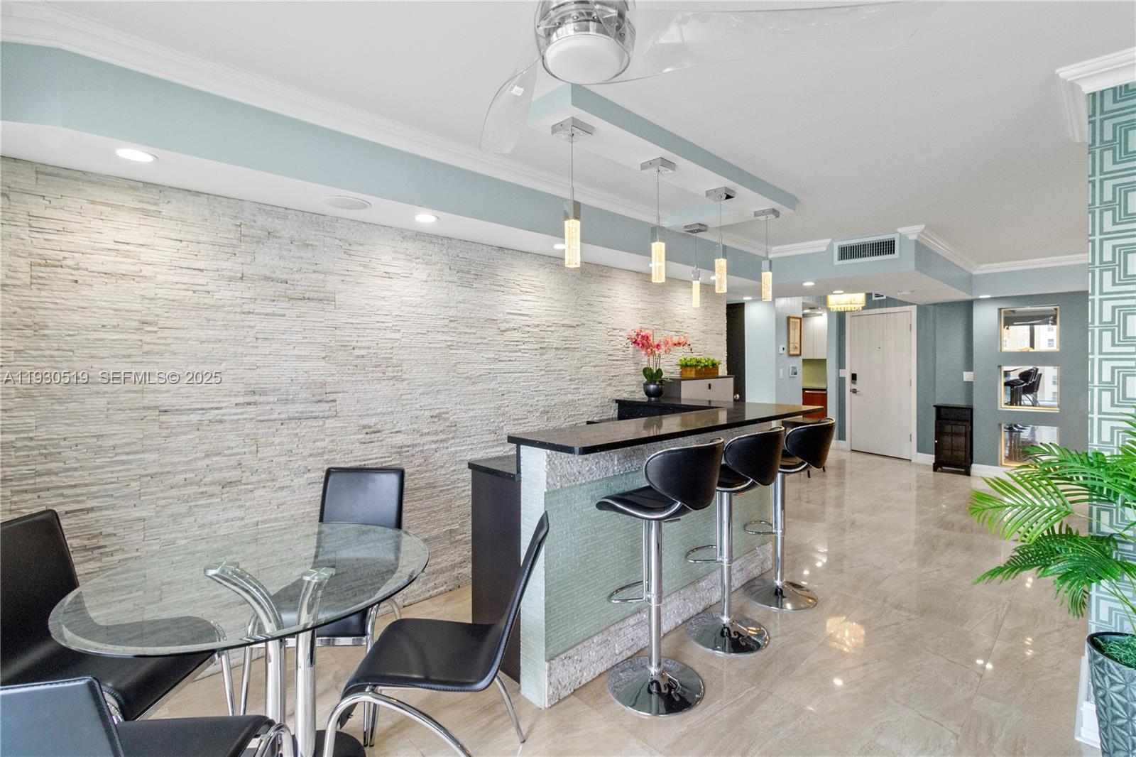 A room features a stone accent wall, a bar with stools, and a glass table — 1880 S Ocean Dr, Hallandale Beach FL 33009, HALLANDALE BEACH, FL