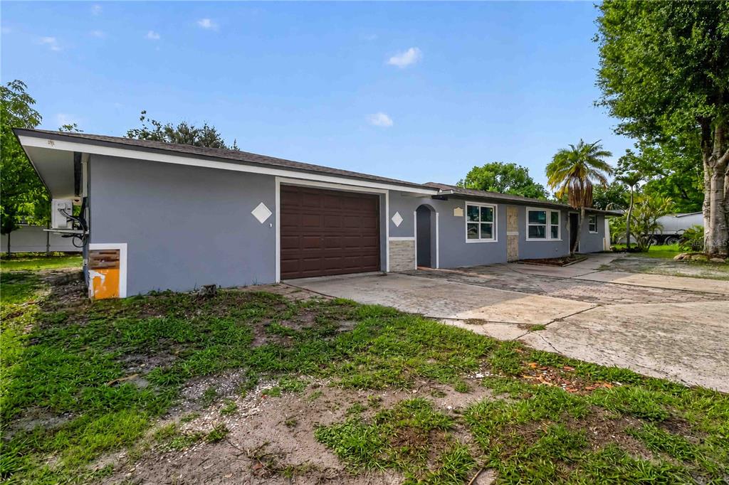 A gray single-story house with a brown garage door and a concrete driveway — 4734 DELMONTE AVENUE, SARASOTA, FL