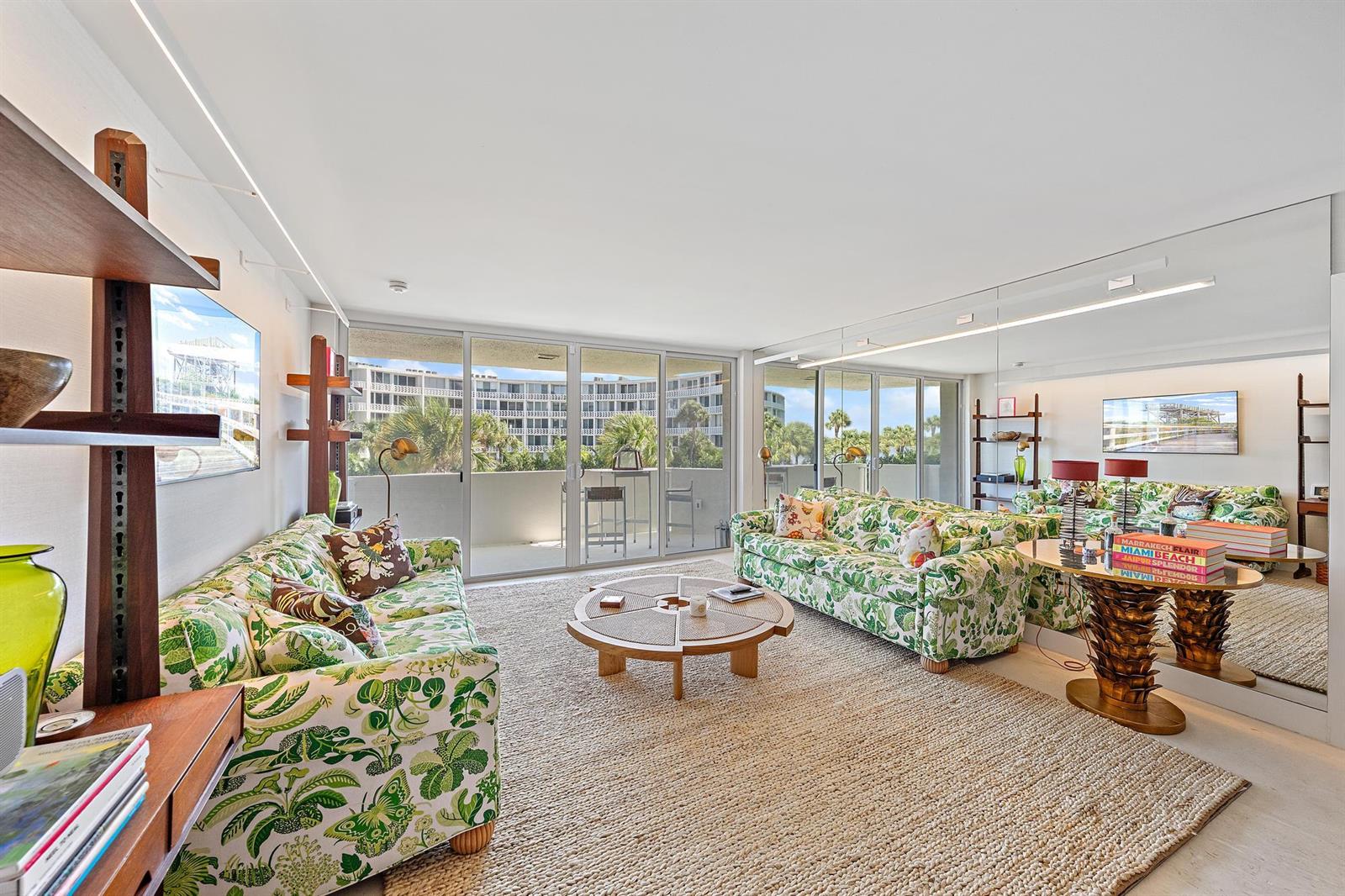 A living room features two floral sofas, a circular coffee table, and a large wall mirror — 2773 S Ocean Boulevard # 209, Palm Beach FL 33480, PALM BEACH, FL
