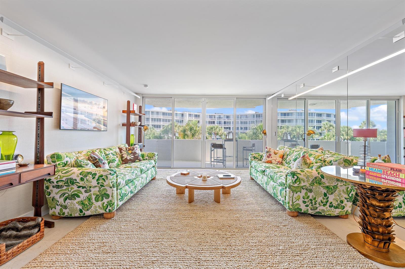A living room features two green patterned sofas, a round coffee table, and sliding glass doors — 2773 S Ocean Boulevard # 209, Palm Beach FL 33480, PALM BEACH, FL