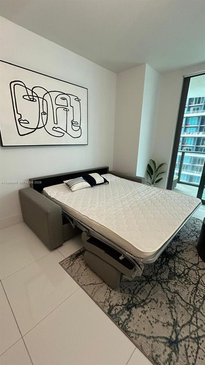 A bedroom features a pull-out sofa bed, a line-art wall print, and a balcony view — 1300 S Miami Ave # 2208, Miami FL 33130, MIAMI, FL