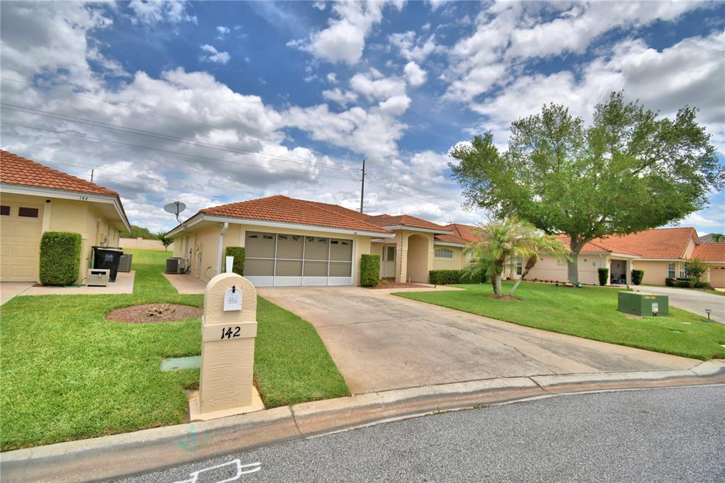 A single-story house with a tiled roof, a two-car garage, and a concrete driveway — 142 MORNING GLORY CIRCLE, WINTER HAVEN, FL