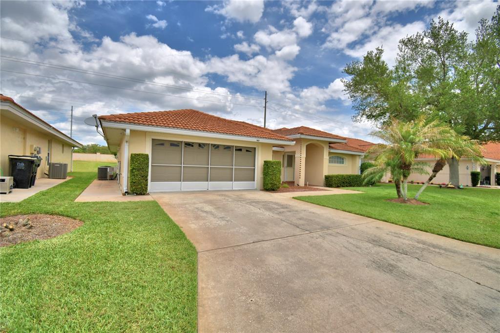 A single-story house with a tiled roof, a two-car garage, and a concrete driveway — 142 MORNING GLORY CIRCLE, WINTER HAVEN, FL