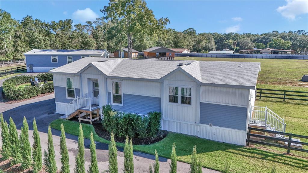 An exterior view of a blue and white manufactured home with a shingled roof — 521 NW 80TH AVENUE, OCALA, FL