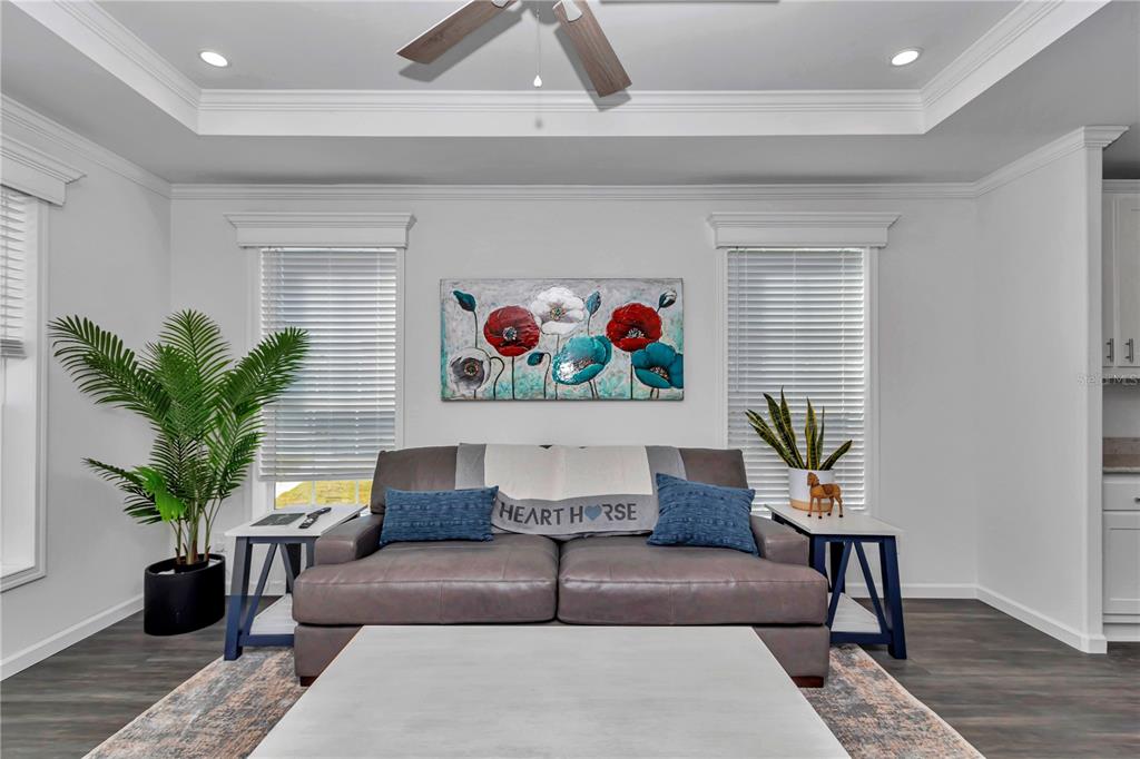 A living room features a grey sofa, floral wall art, and two side tables — 521 NW 80TH AVENUE, OCALA, FL