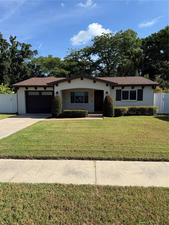 A single-story house with a brown roof, white stucco exterior, and a small front lawn — 197 IRWIN STREET W, SAFETY HARBOR, FL