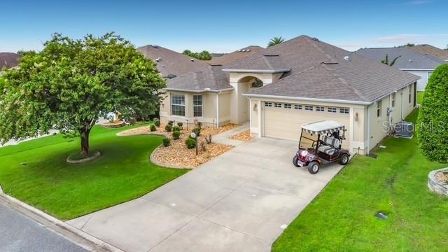 An exterior view of a single-story house with a golf cart parked on the driveway — 3240 LAFAYETTE STREET, THE VILLAGES, FL