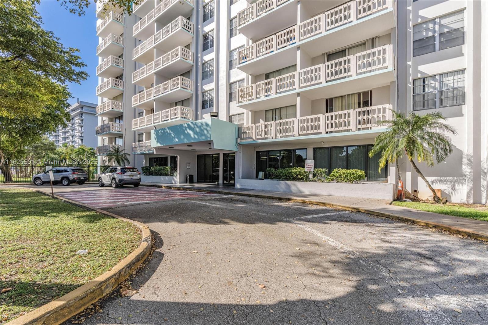 The exterior of a multi-story apartment building features balconies with decorative railings and a covered entrance — 15600 NW 7th Ave # 306, Miami FL 33169, MIAMI, FL