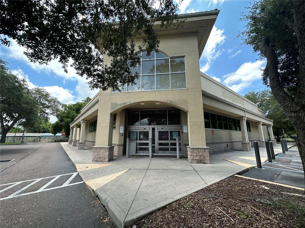 The exterior of a commercial building features a tan facade, arched entrance, and glass windows — 3917 N NEBRASKA AVENUE, TAMPA, FL