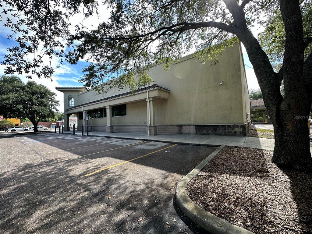 A beige commercial building exterior with a parking lot and large shade trees — 3917 N NEBRASKA AVENUE, TAMPA, FL