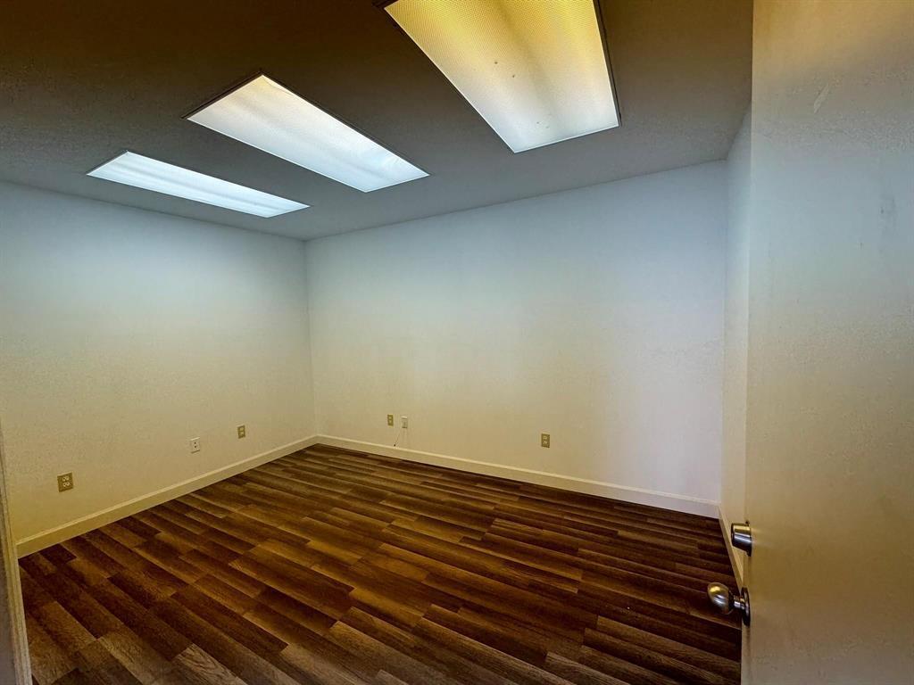 An empty room features white walls, recessed lighting, and wood-look flooring — 1773 Blount Road # 313, Pompano Beach FL 33069, POMPANO BEACH, FL