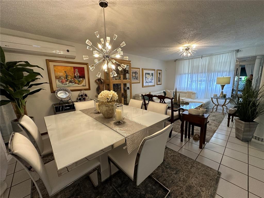 A dining area with a white table and chandelier opens into a living room space — 57 LOPATEGUI UNIT BB-2, GUAYNABO, PR