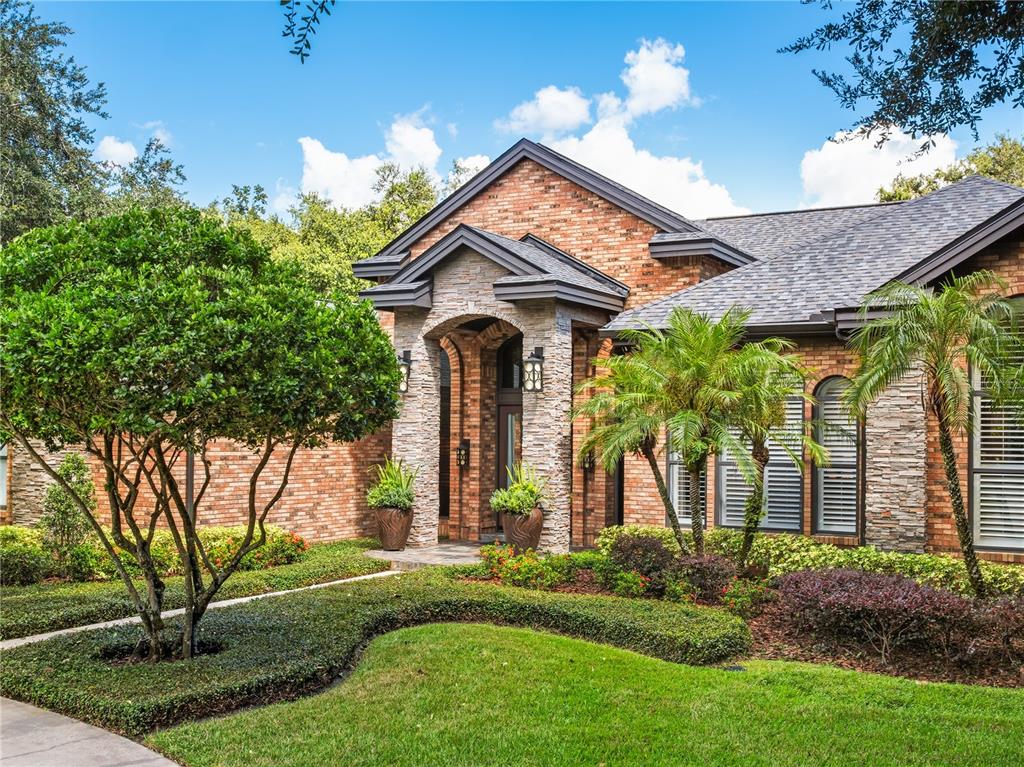 A grand foyer features hardwood floors, arched wall niches, and a dark-framed double door entrance — 16211 VILLARREAL DE AVILA, TAMPA, FL