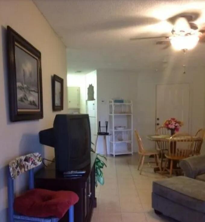 A living room with a television, a dining area, and a white shelving unit — 1971 NE Collins Circle # 20, Jensen Beach FL 34957, JENSEN BEACH, FL