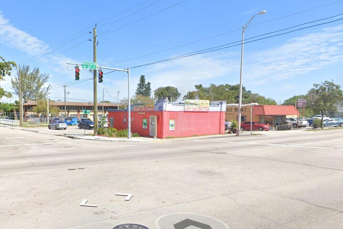 A red corner building sits at an intersection with traffic lights and a street sign — 2467 NW 62nd St, Miami FL 33147, MIAMI, FL