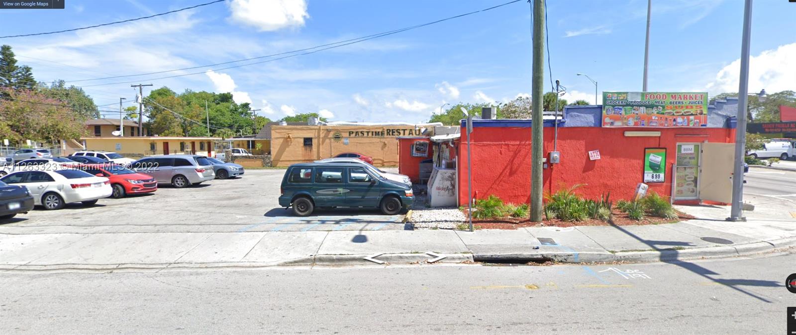 A red commercial building with a food market sign sits next to a parking lot — 2467 NW 62nd St, Miami FL 33147, MIAMI, FL