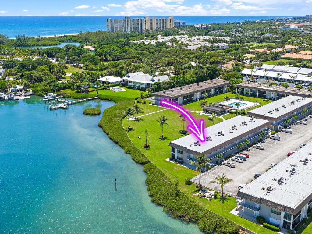 An aerial view shows a multi-story waterfront condominium complex with a large grassy lawn — 755 Saturn D205 Street # D205, Jupiter FL 33477, JUPITER, FL
