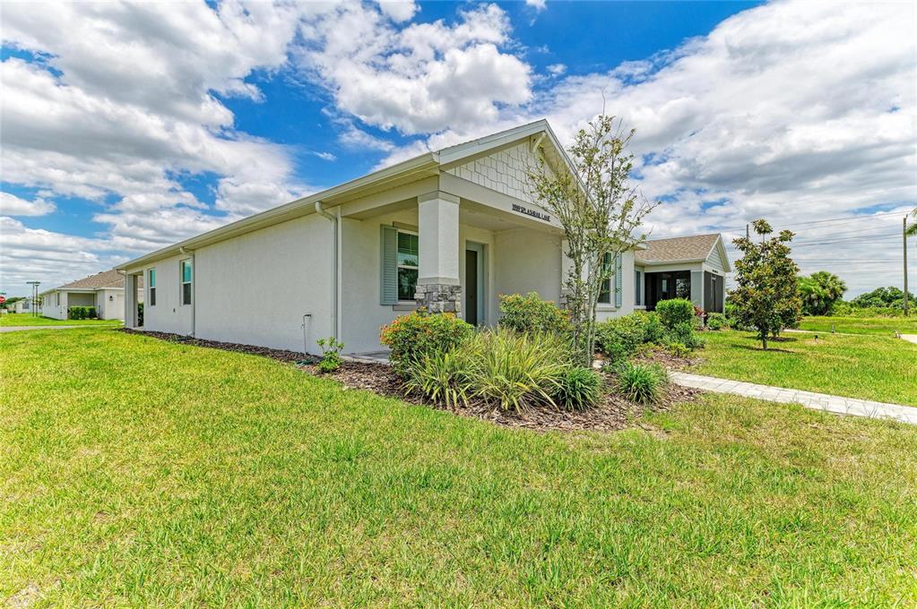 A single-story house with a light-colored stucco exterior and a covered front entryway — 1989 SPLASHRAIL LANE, SARASOTA, FL