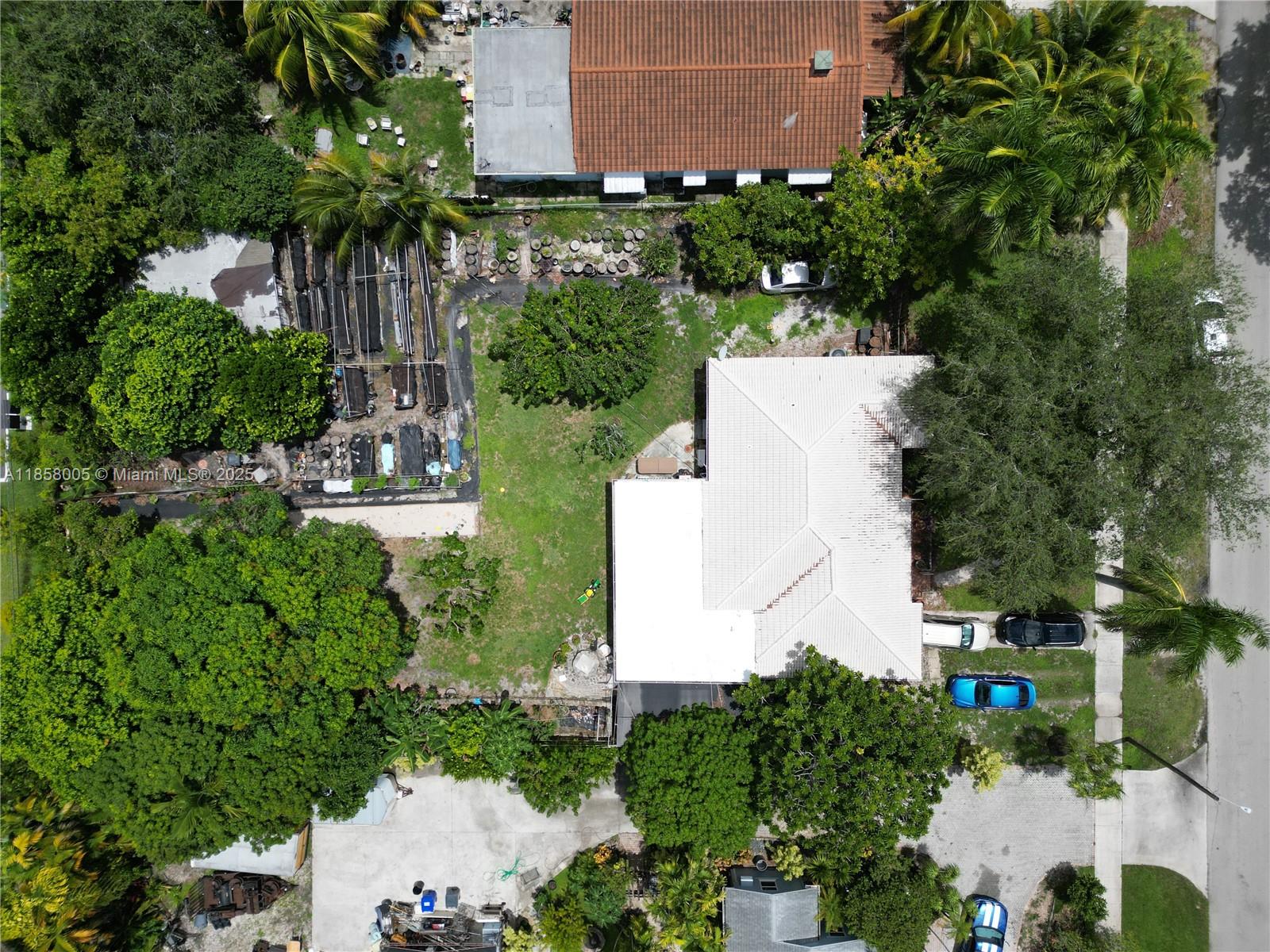 An aerial view shows a house with a white roof, a large yard, and trees — 2527 Fillmore St, Hollywood FL 33020, HOLLYWOOD, FL