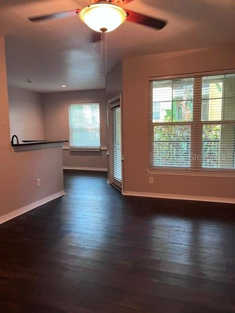 A room with dark wood-look flooring, a ceiling fan, and large windows with blinds — 1810 E PALM AVENUE UNIT 1117, TAMPA, FL