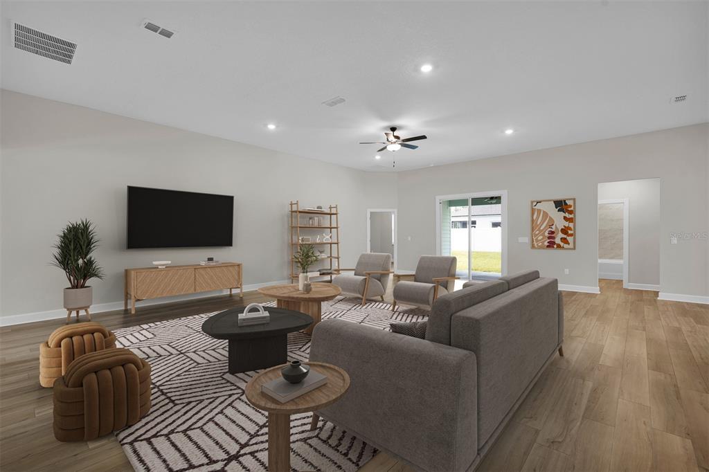 This is a digital rendering of a spacious living room with neutral walls and wood flooring — 17399 SW 26TH TERRACE ROAD, OCALA, FL