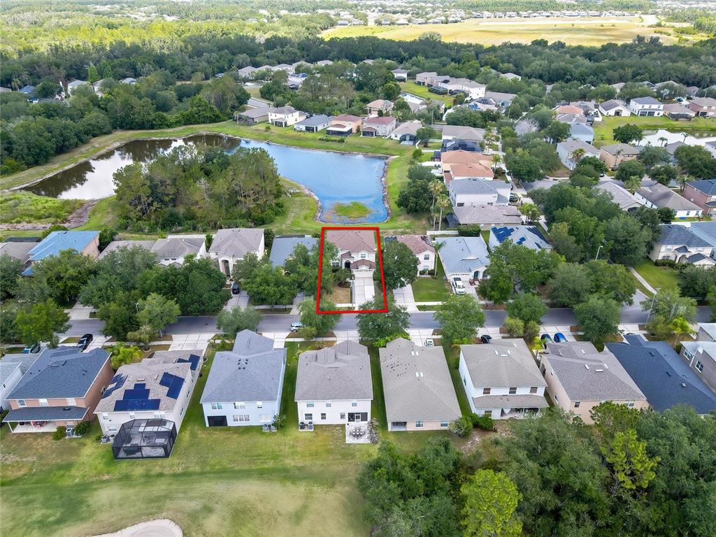 An aerial view shows a suburban neighborhood with a highlighted house facing a lake — 10536 CORAL KEY AVENUE, TAMPA, FL