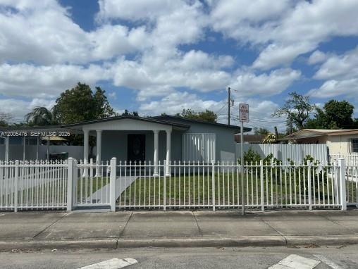 A gray house exterior features a covered porch with three white columns and a door — 841 Hialeah Dr, Hialeah FL 33010, HIALEAH, FL