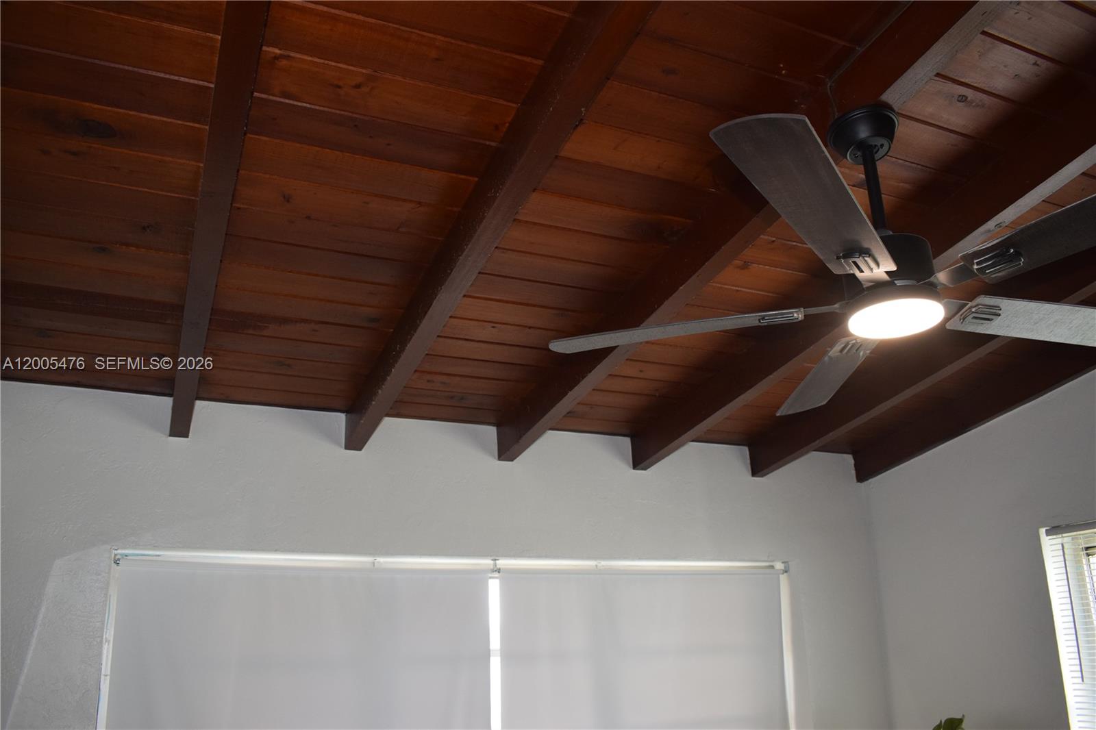 A room features a dark wood plank ceiling with exposed beams and a ceiling fan — 841 Hialeah Dr, Hialeah FL 33010, HIALEAH, FL