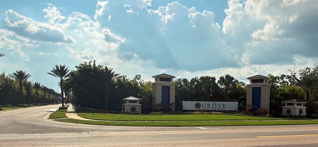 A stone entrance sign for The Grove Resort & Waterpark sits beside a paved road — 14501 GROVE RESORT AVENUE UNIT 3712, WINTER GARDEN, FL
