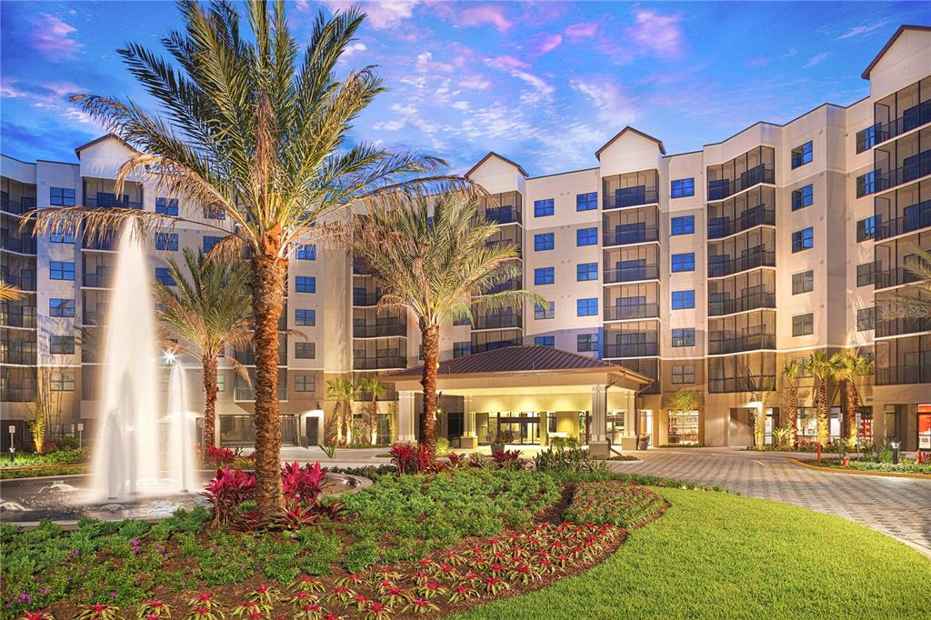 A multi-story apartment building exterior features a fountain, palm trees, and a covered entrance — 14501 GROVE RESORT AVENUE UNIT 3712, WINTER GARDEN, FL