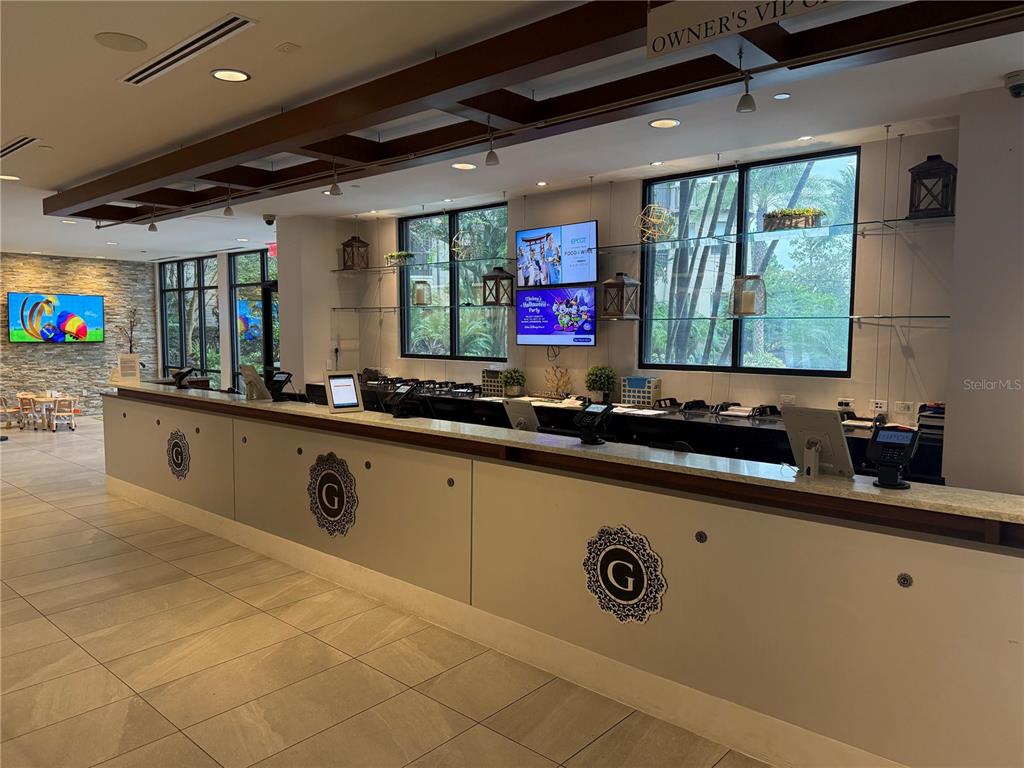 A reception desk with a logo sits in a room with large windows and screens — 14501 GROVE RESORT AVENUE UNIT 3712, WINTER GARDEN, FL