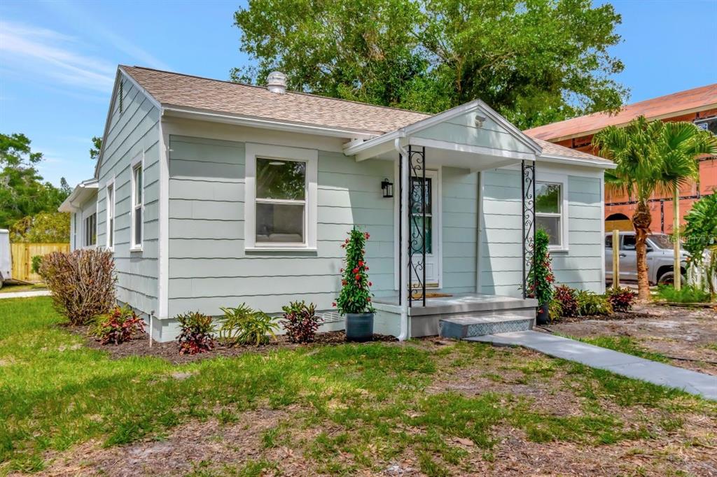 A light green, single-story house with a small front porch and a concrete walkway — 1419 55TH STREET S, GULFPORT, FL
