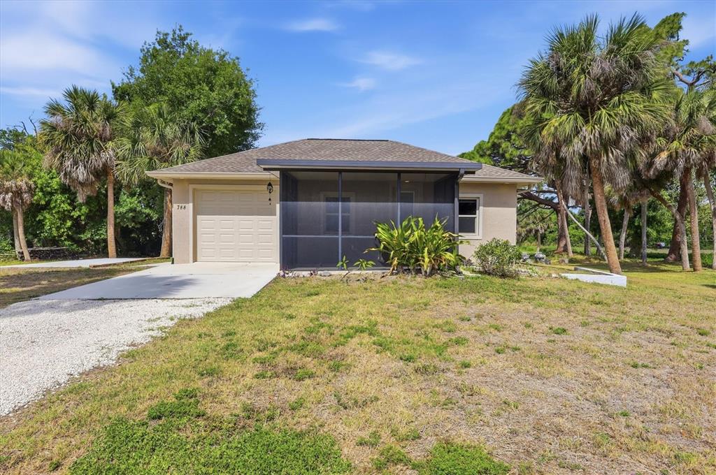 A single-story house with a garage and a screened-in front porch sits on a lawn — 788 HARMONY LANE, ENGLEWOOD, FL